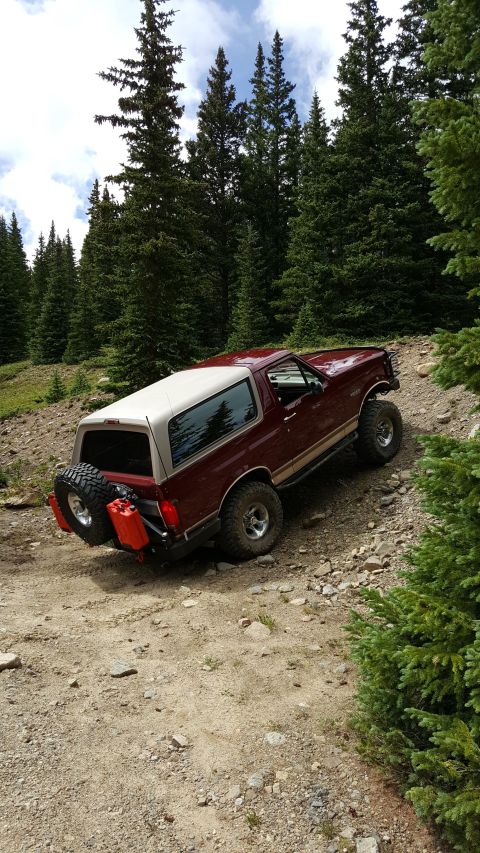 1996 Ford Bronco - This 1996 Ford Bronco navigates a rocky mountain trail, equipped with a spare tire and auxiliary fuel cans.