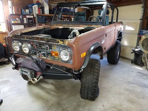 1972 Ford Bronco - This 1972 Ford Bronco is undergoing restoration in a garage, an open hood and a winch mounted on the front bumper.