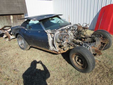 Dark blue 1976 Chevrolet Corvette with front end removed, sitting outside