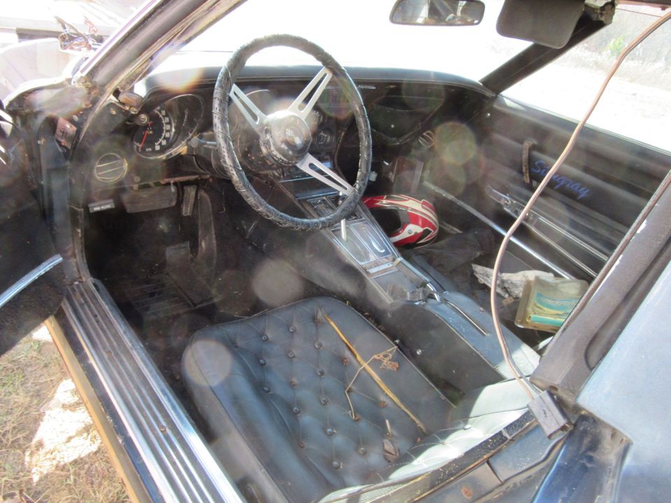 1976 Chevrolet Corvette interior with cracked dashboard and torn seats