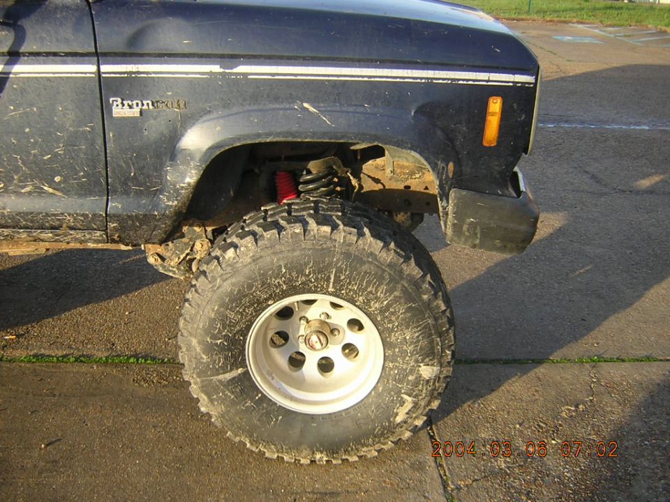 Dark blue SUV front fender with 'Bronco II' badge and large off-road tire