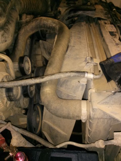 1996 Ford Bronco - The image shows a close-up view of the engine bay of a 1996 Ford Bronco, focusing on the radiator, fan, and hoses. The engine components ar…