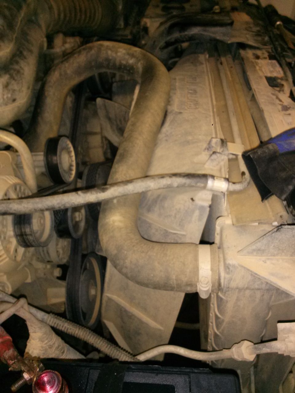 Engine bay of a 1996 Ford Bronco, showing radiator, fan, and hoses covered in dust.