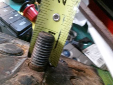 1996 Ford Bronco - A close-up shot shows a rusty bolt next to a yellow measuring tape, with a black electronic device visible in the background.