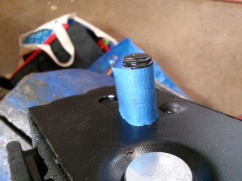 1996 Ford Bronco - A close-up shot shows a threaded bolt with blue painter's tape wrapped around its base, securing it to a black metal bracket. The bracket a…