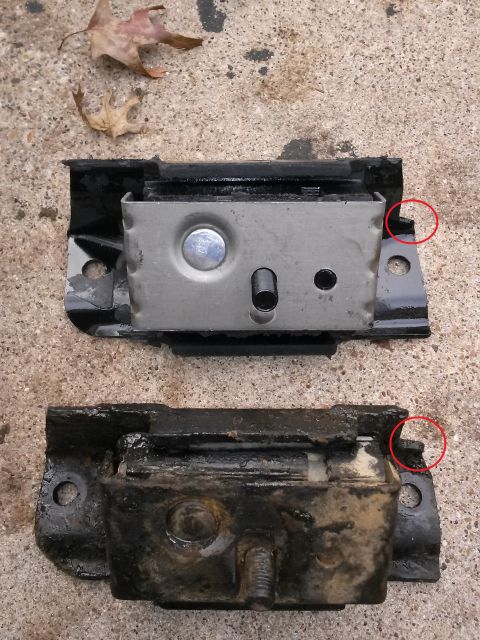 1996 Ford Bronco - Two engine mounts are shown side-by-side on a concrete surface. The top mount appears newer and cleaner, while the bottom mount is older, d…