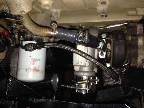 1994 Ford Bronco - A close-up view of a turbocharger and oil filter assembly mounted on a vehicle's engine. The turbocharger has a black Samco Sport hose atta…