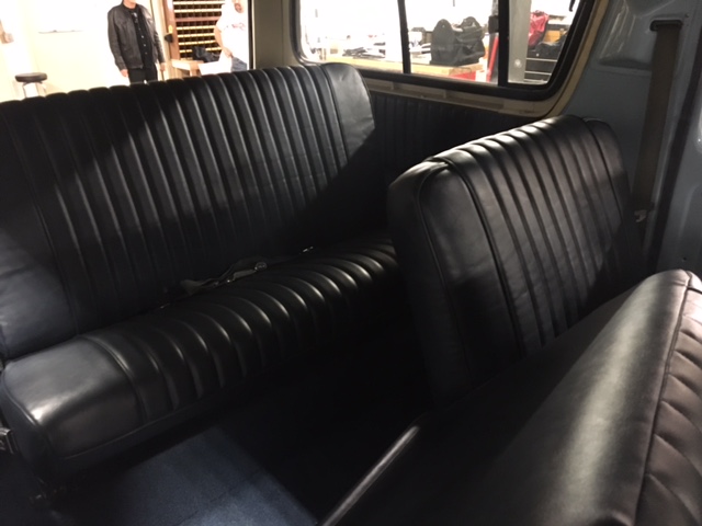 Black ribbed vinyl bench seats in a vehicle interior.