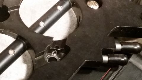 1981 Ford Bronco - A close-up view shows a black metal component with silver pins and black cylindrical protrusions. The part appears to be a mechanical assem…