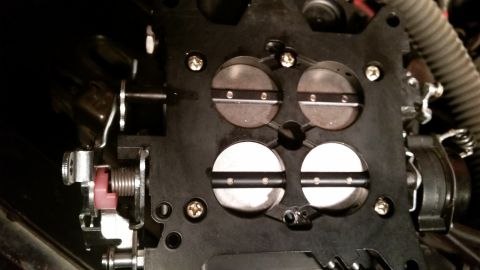 1981 Ford Bronco - A close-up view of the throttle plates and linkage of a carburetor, likely from a 1981 Ford Bronco.