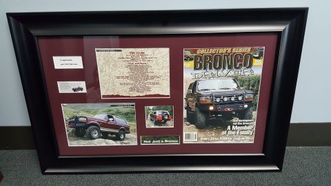 1996 Ford Bronco - A framed collection of Bronco memorabilia, including a magazine cover and photos of the vehicle.