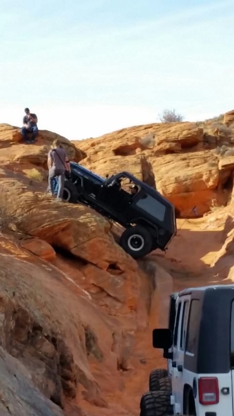 1979 Ford Bronco - Off-roading adventure: a black Jeep navigates a challenging rocky terrain while another vehicle waits behind.