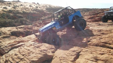 1979 Ford Bronco - Two off-road vehicles navigate a rocky desert terrain.