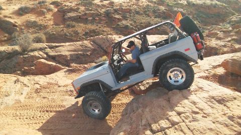 1979 Ford Bronco - This 1978 Ford Bronco is navigating a challenging off-road trail in a desert landscape.