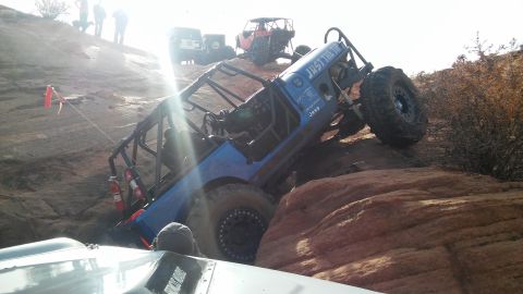 1979 Ford Bronco - An off-road Jeep navigates a steep, rocky incline with other vehicles nearby.