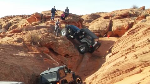 1979 Ford Bronco - Off-road vehicles tackle challenging terrain in a desert landscape.