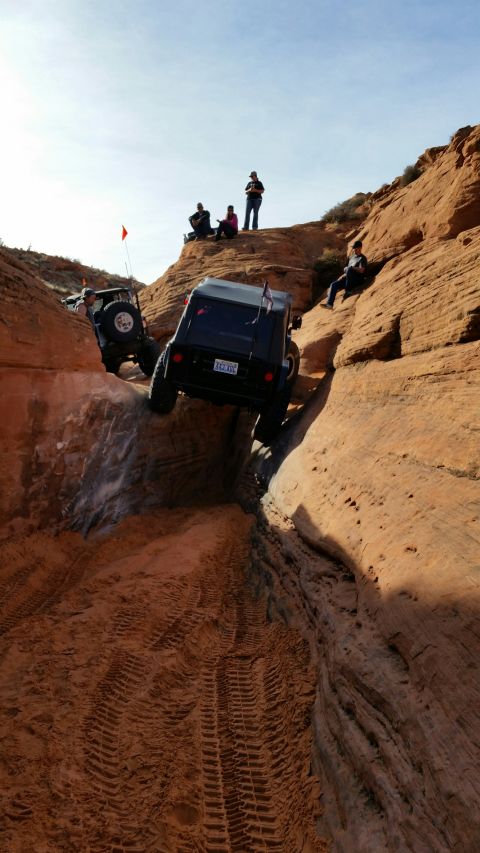 1979 Ford Bronco - Off-road vehicles navigate a challenging sandy canyon trail with spectators observing the descent.