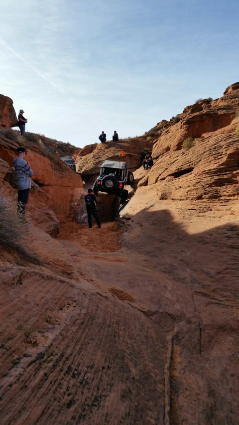 1979 Ford Bronco - Off-road vehicles navigate a steep, sandy canyon trail with onlookers observing the challenging terrain.