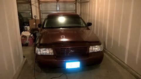 2004 Ford Crown Victoria - Front view of a maroon 2004 Ford Crown Victoria parked inside a garage.