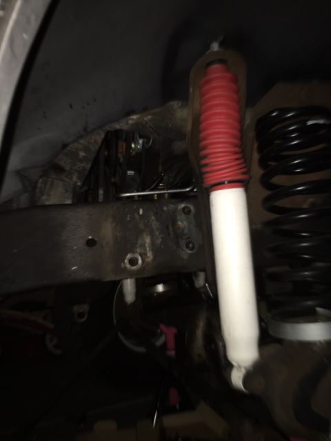 1978 Ford Bronco - The image shows a close-up view of a vehicle's suspension system, including a shock absorber and coil spring.
