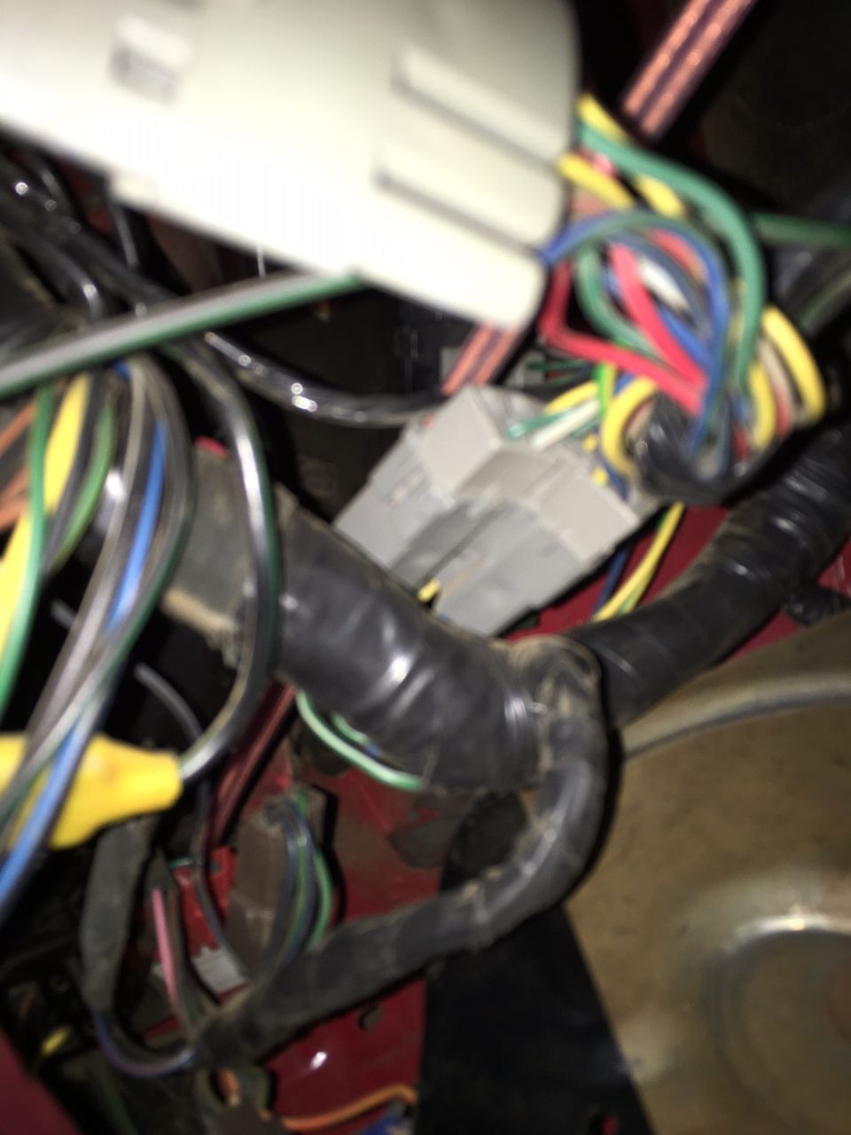 close-up of a tangled vehicle wiring harness with multiple colored wires and connectors
