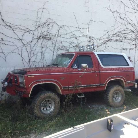 1995 Ford Bronco - This red Ford Bronco with a white top appears to be from the early 1980s, not a 1995 model.