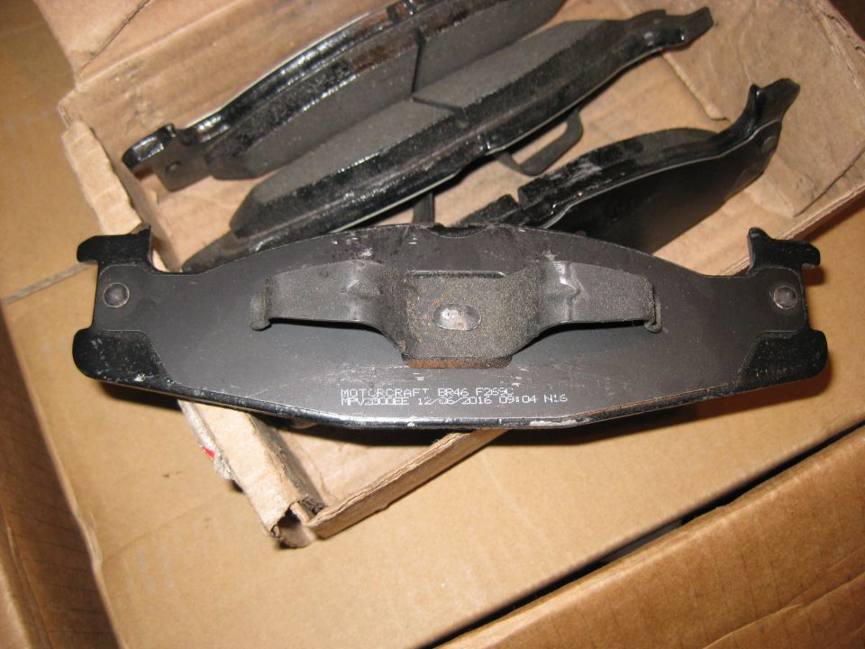 Set of new brake pads in a cardboard box. Text on one pad reads MOTORCRAFT BB46 F263C