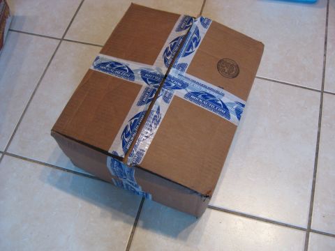 1994 Ford Bronco - A sealed cardboard box with RockAuto.com branded tape sits on a tiled floor.