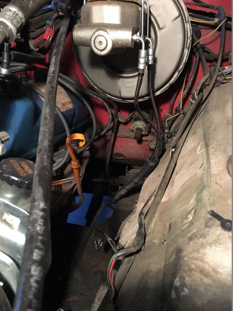 1978 Ford Bronco - This image shows a close-up view of the brake master cylinder and various hoses and wires within a vehicle's engine bay.