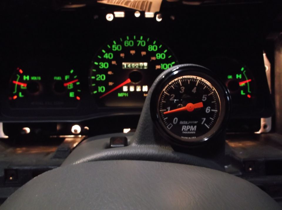 Dashboard gauges with a new tachometer installed. Speedometer reads 140,209