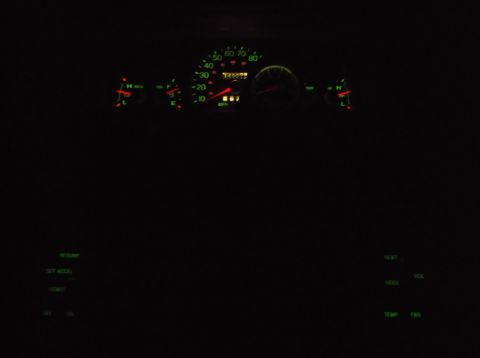 1999 Mercury Grand Marquis - The illuminated dashboard of a 1999 Mercury Grand Marquis at night shows a speedometer, tachometer, fuel gauge, and temperature gauge. Vari…