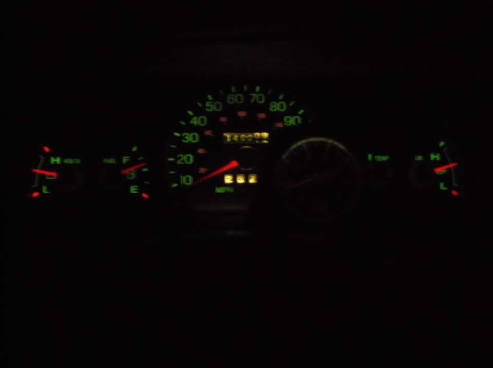 Illuminated dashboard of a 1999 Mercury Grand Marquis with speedometer, odometer, fuel, voltage, and temperature gauges.