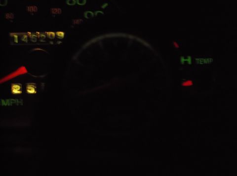 1999 Mercury Grand Marquis - The image shows a close-up of a car's dashboard at night, displaying the odometer reading of 146209 and the speedometer at 25 MPH. A temper…