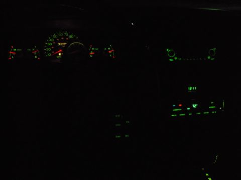 1999 Mercury Grand Marquis - The interior of a car at night shows the illuminated dashboard gauges and climate controls. The speedometer shows a reading of approximatel…