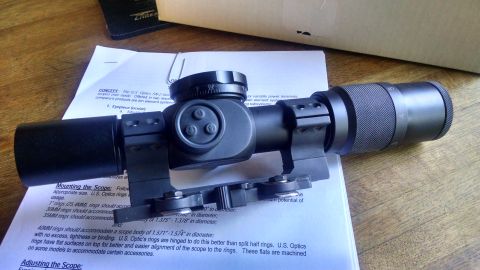1996 Ford Bronco - A close-up view of a rifle scope mounted on rings, resting on a document with instructions.