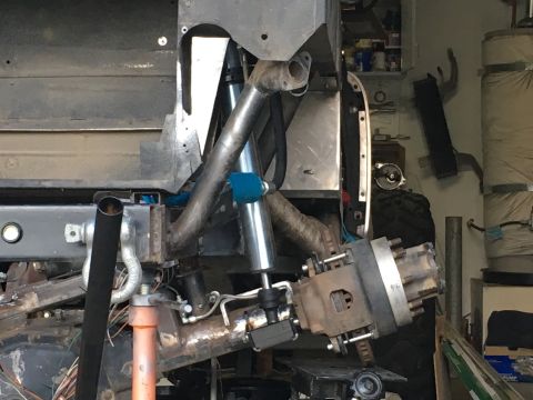 1961 International Scout 800 - Custom suspension parts for an off-road vehicle are visible in this workshop setting.