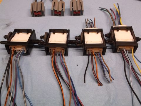 1999 Mercury Grand Marquis - Multiple automotive wiring harnesses are laid out on a blue cloth surface, ready for installation or repair.