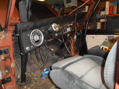 1972 Ford Bronco - The dashboard of a vehicle is shown with a complex network of wires exposed during what appears to be a restoration or repair process.