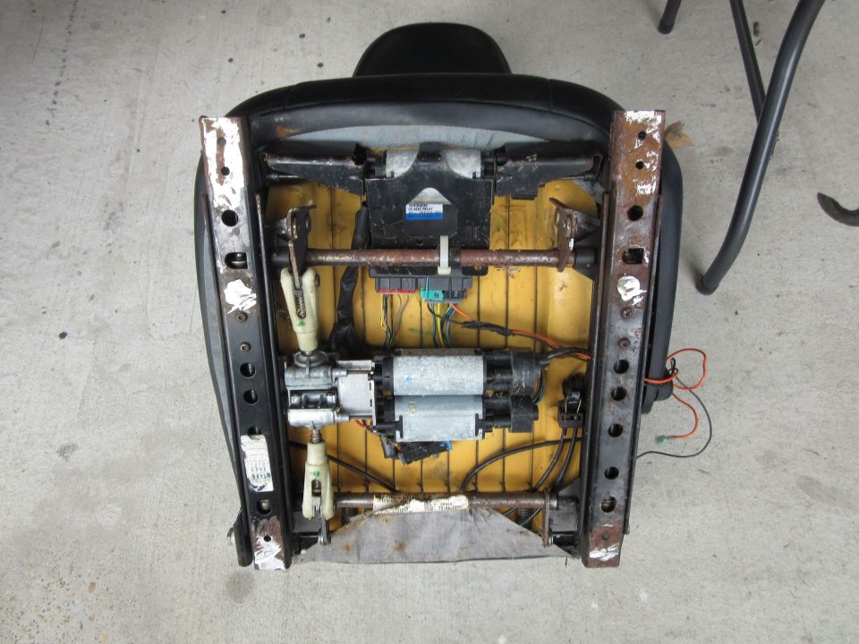 Car seat underside with exposed motors and wiring