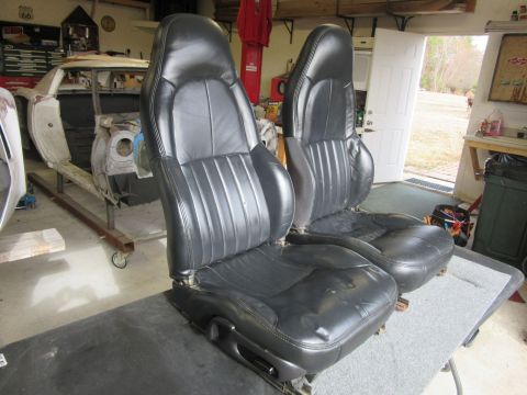 Pair of black leather car seats with ribbed upholstery