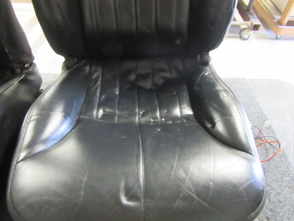 black leather car seats, one is partially visible on the left
