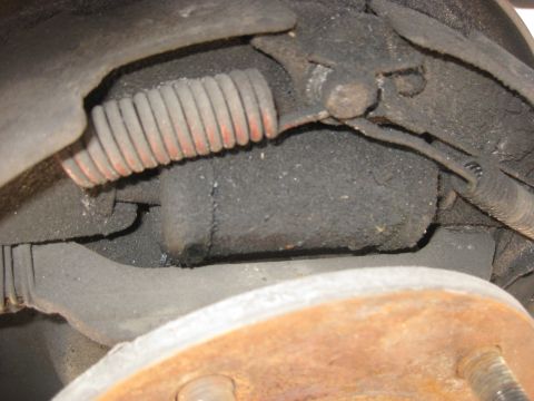 1994 Ford Bronco - Close-up view of a rear drum brake assembly, showing a spring and brake shoe mechanism.
