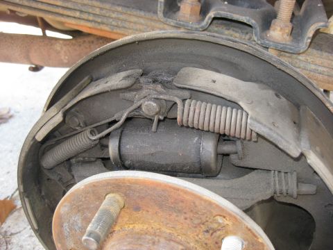 1994 Ford Bronco - Drum brake assembly showing internal components like shoes, springs, and wheel cylinder. SuperMotors.net logo visible.
