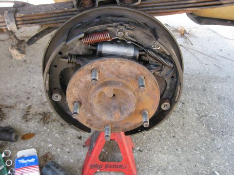 1994 Ford Bronco - Vehicle's drum brake assembly is shown disassembled and supported by a jack stand.