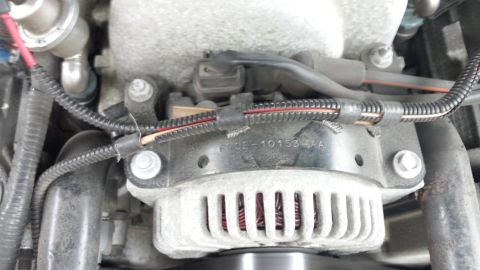 1998 Lincoln Mark VIII - This image shows a close-up view of an engine's alternator and associated wiring, with a visible part number.