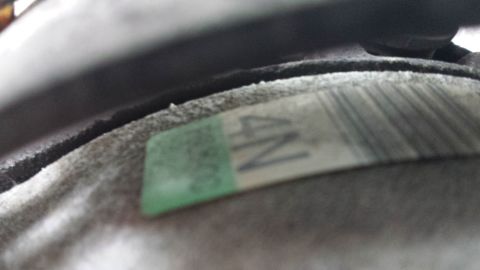 1998 Lincoln Mark VIII - A close-up view of a label with text and a barcode on a vehicle part.