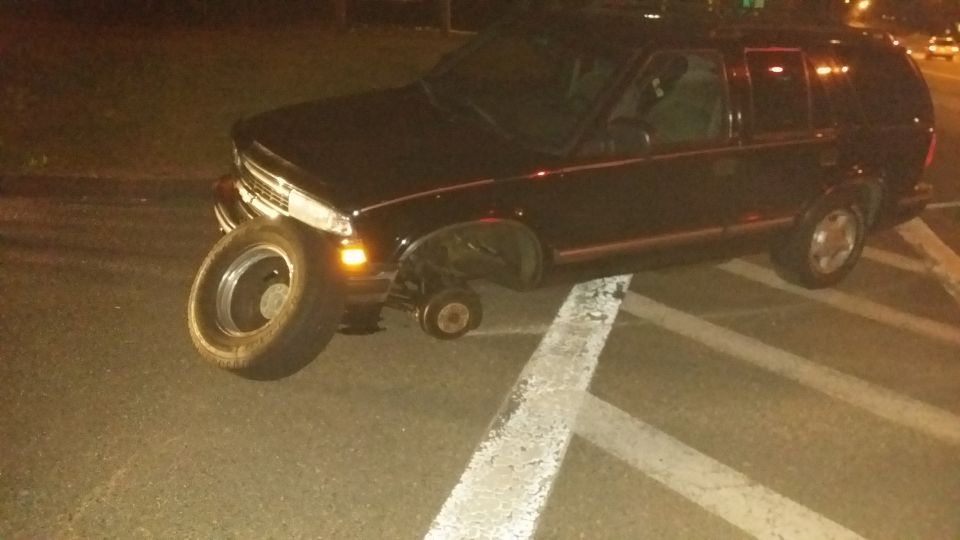 1999 Chevrolet Blazer with front passenger wheel and rear driver wheel removed, parked on white lines