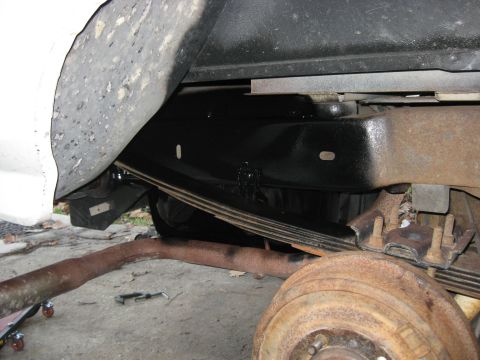 1994 Ford Bronco - Close-up view of the undercarriage, showing the frame, suspension, and exhaust system of a vehicle.