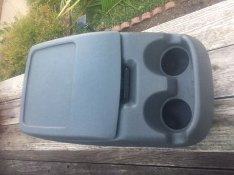 1986 Ford Bronco - This gray center console features two cupholders and a storage compartment, likely for a truck or SUV.