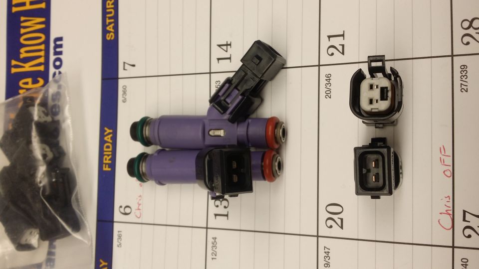 Two purple fuel injectors and two electrical connectors on a calendar page